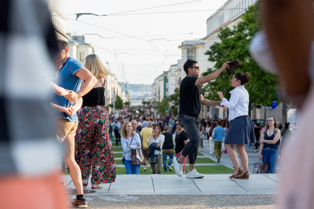 Un couple danse entouré de monde.