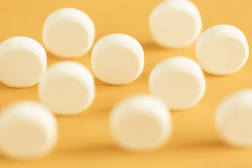 des pilules blanches sur fond jaune