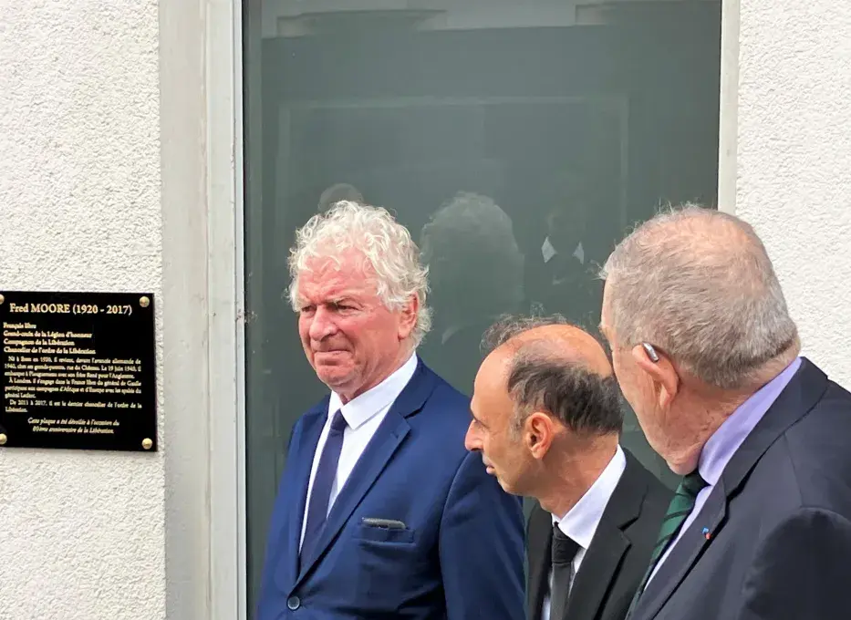 Des hommes devant une plaque d'hommage à un ancien combattant brestois