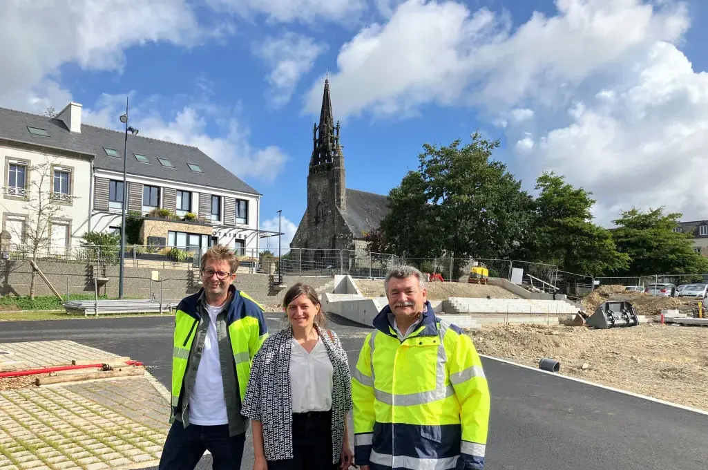 une femme et deux hommes sur la place du marché en travaux, à Guipavas.