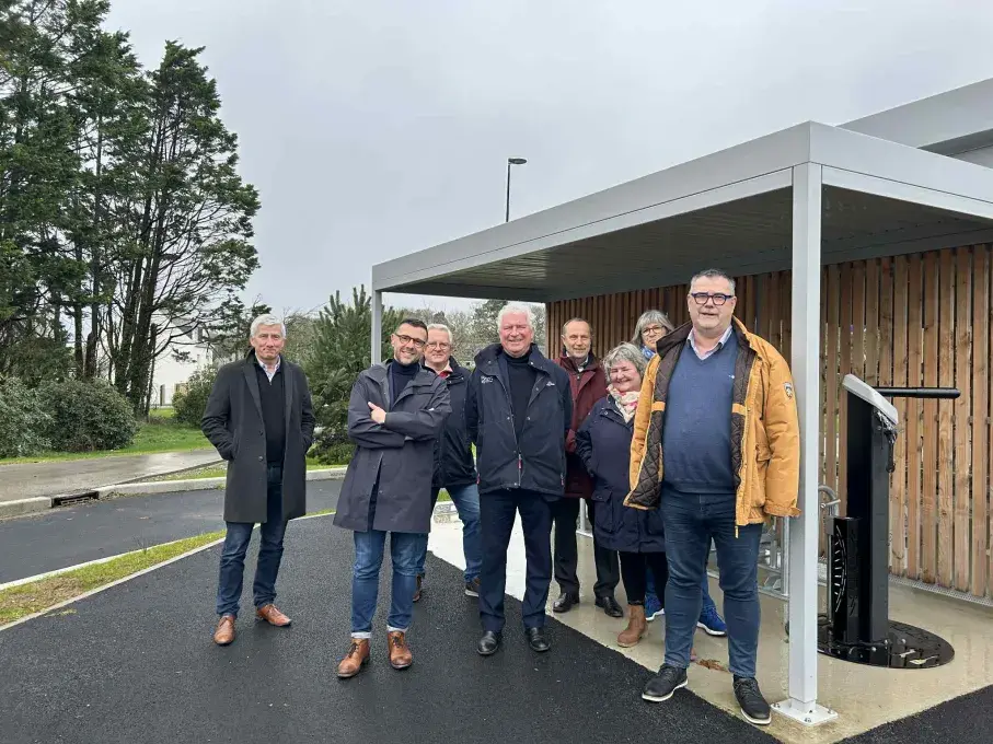Un groupe de personnes debout devant un abri à vélo
