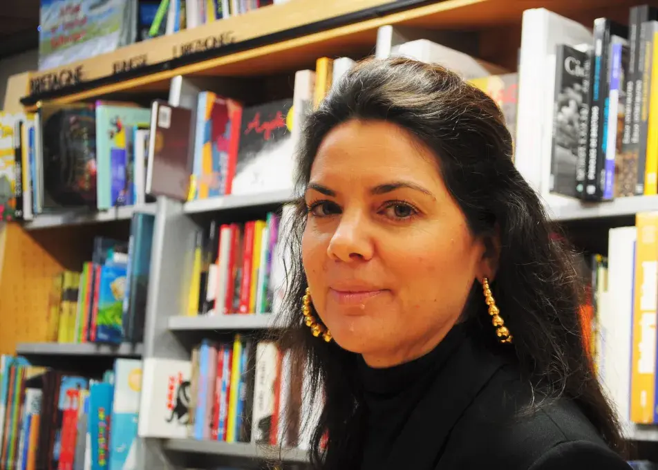 Une femme devant des étagères de livres