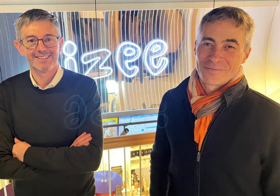 Deux hommes devant une enseigne lumineuse