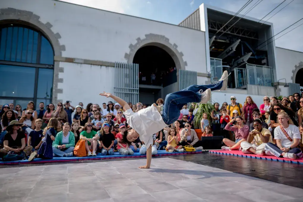 une scène, un danseur de hip hop et du public sur le parvis Cesaria Evora