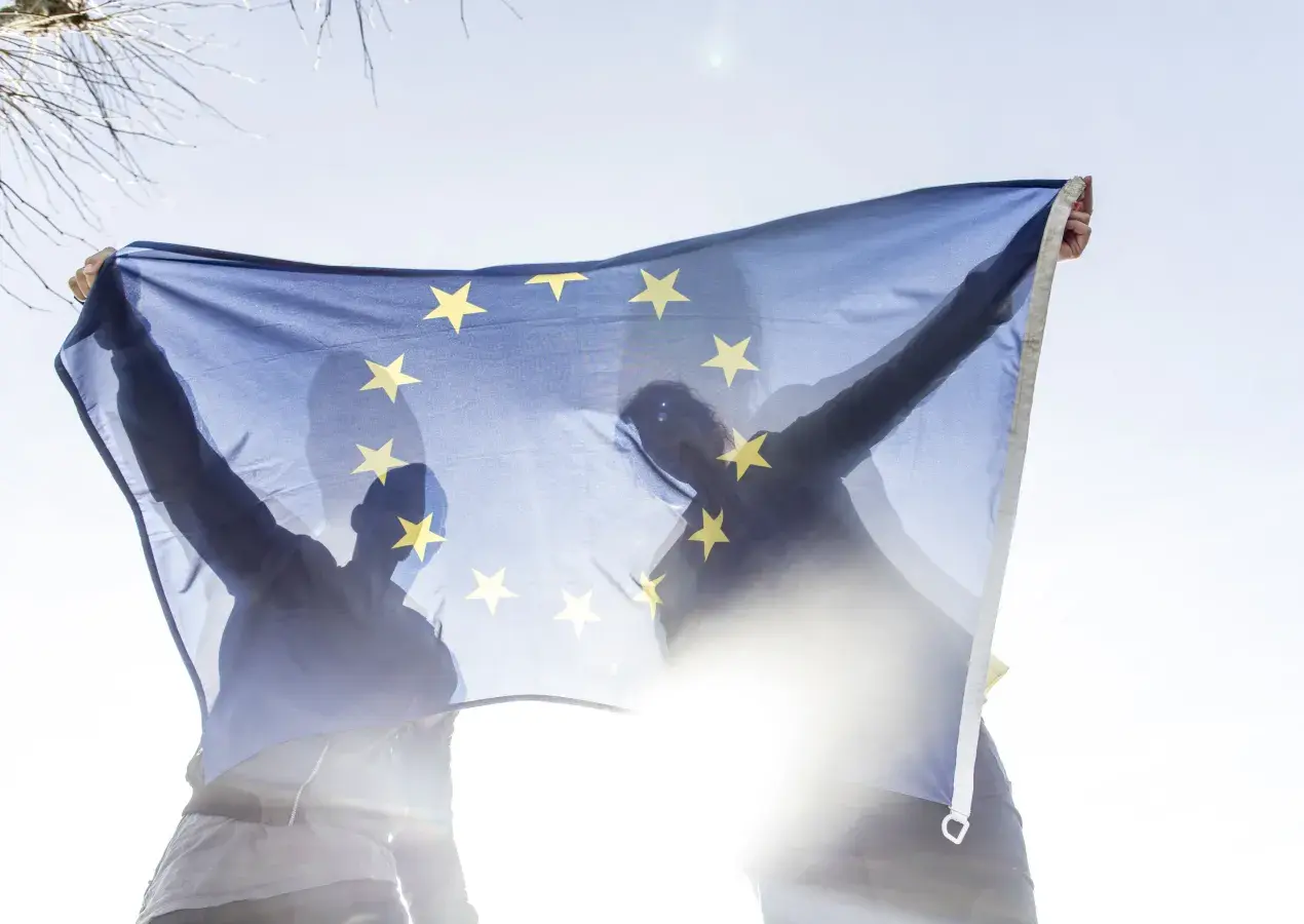 Deux personnes tiennent un drapeau européen.