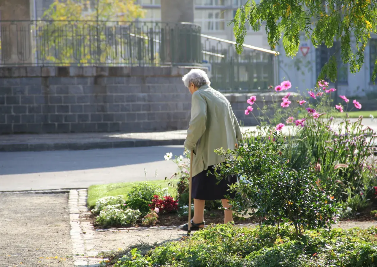Une personne âgée dans un square.
