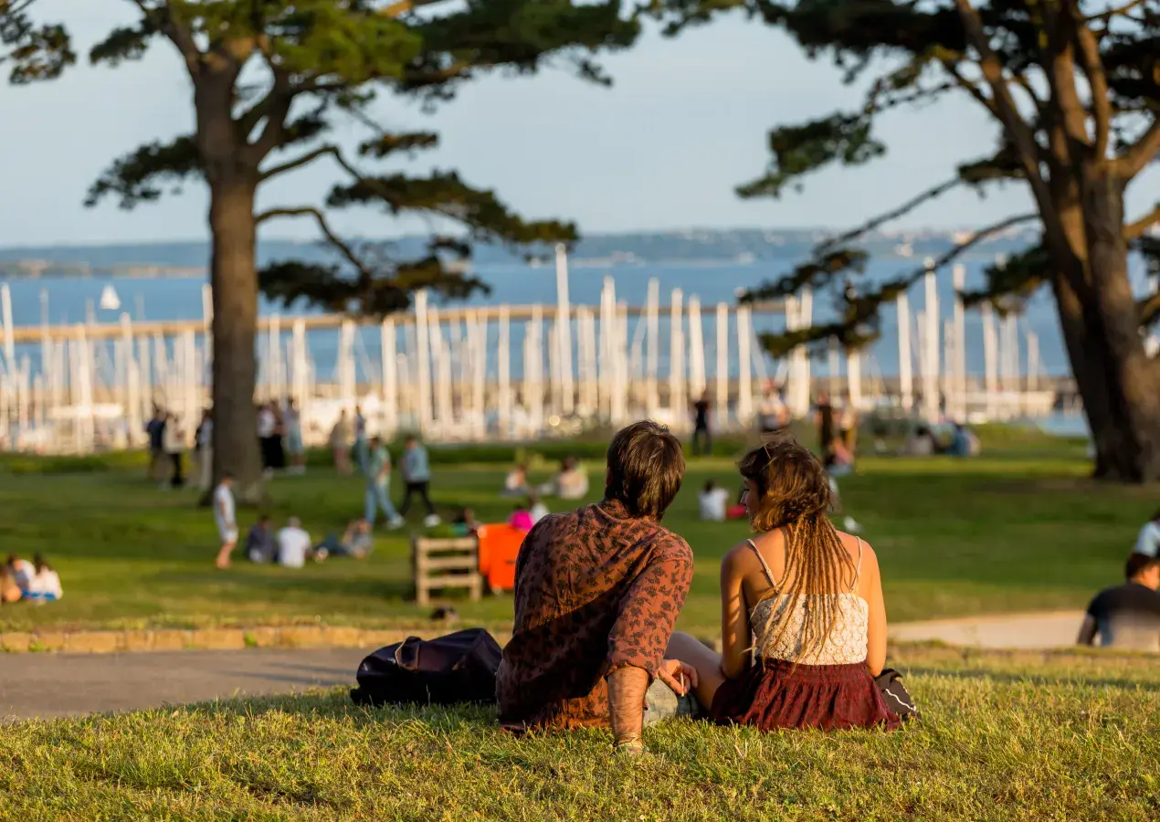 Deux personnes assises sur l'herbe sur l'esplanade du château
