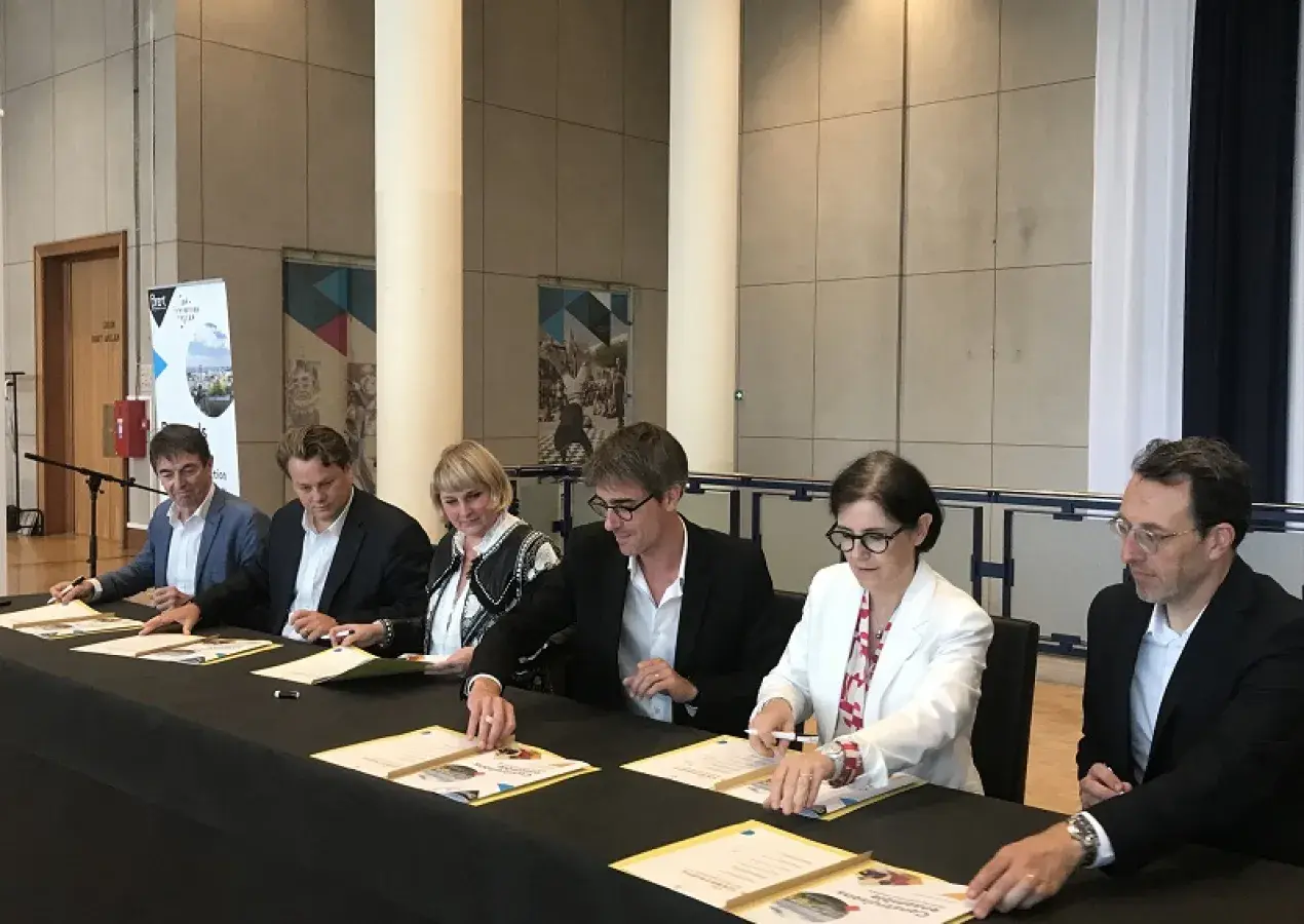 Des hommes et des femmes signent une convention à l'hôtel de ville de Brest 