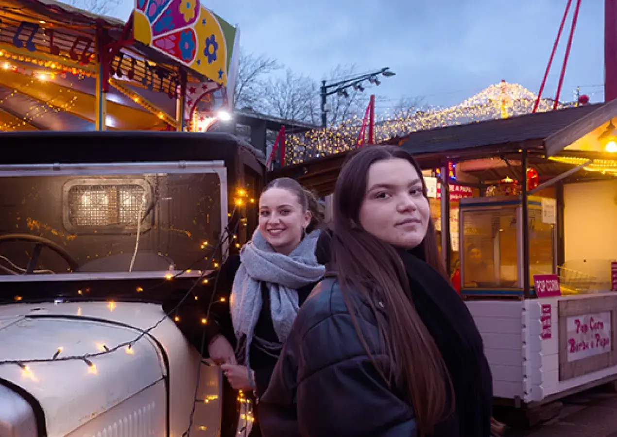 Deux jeunes femmes posant au marché de Noël