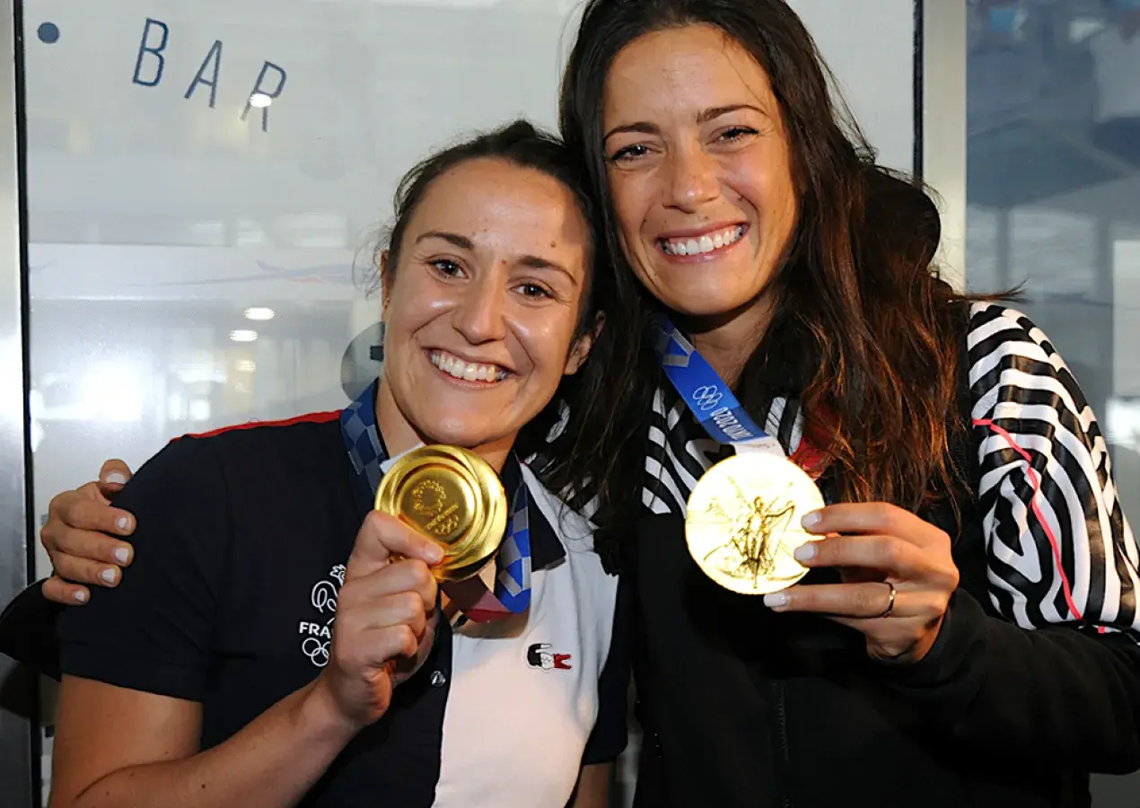 deux femmes montrant leurs médailles d'or