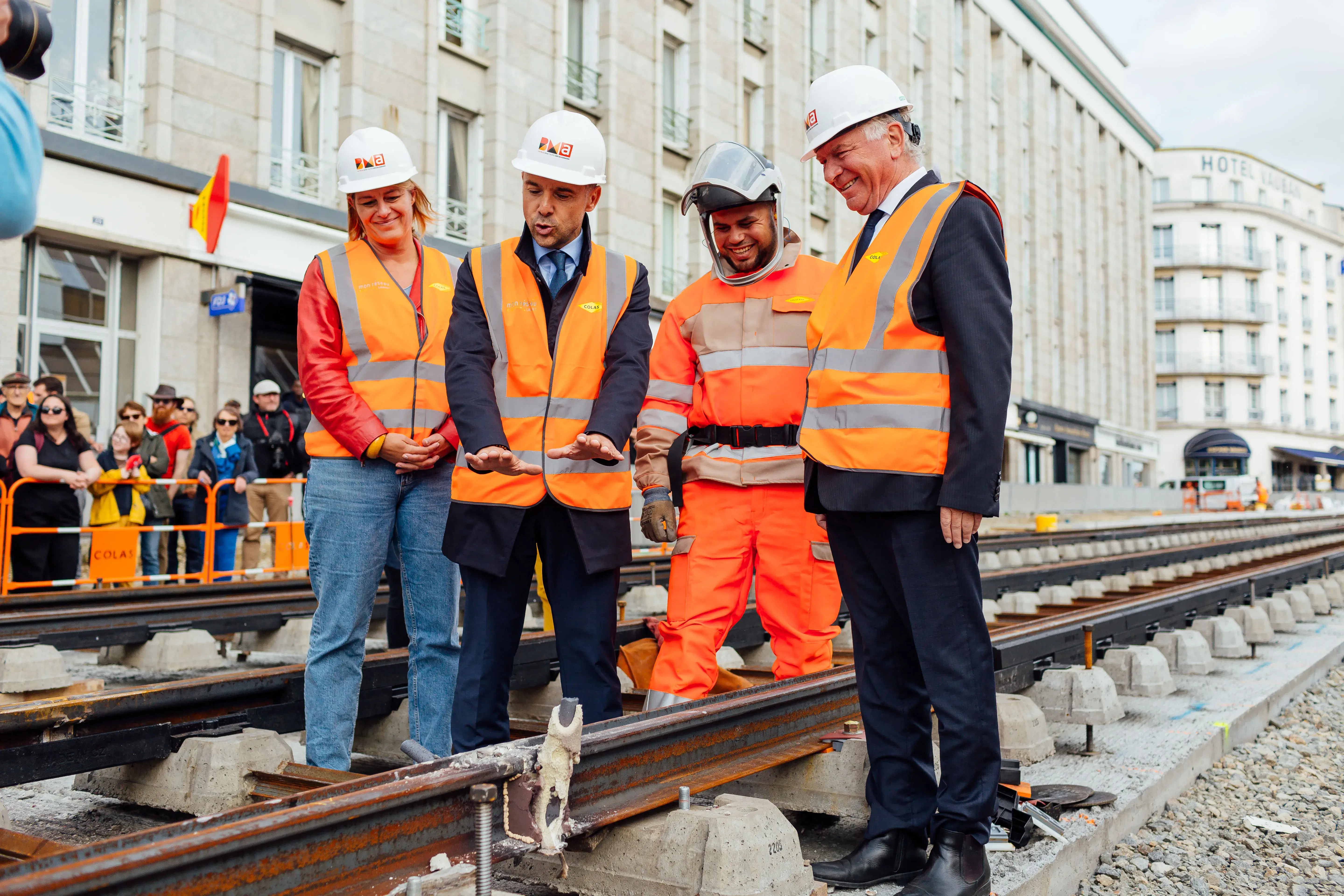 Des gommes et une femme regardent la première soudure de rails sur la ligne B du tramway de Brest.  