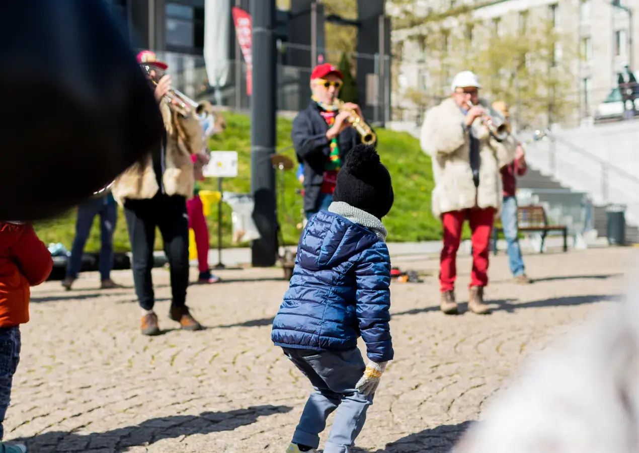 Un enfant danse devant des musiciens.