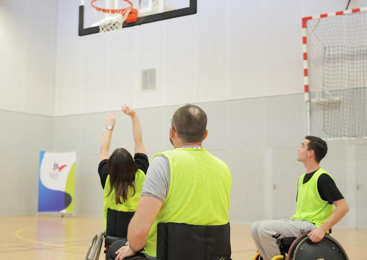 Des personnes en fauteuil roulant jouent au basket.