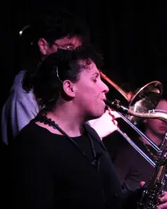 Photo montrant une jeune femme jouant du saxophone et un jeune homme jouant du trombone