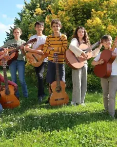 Photo montrant 5 jeunes guitaristes posant en extérieur dans un parc