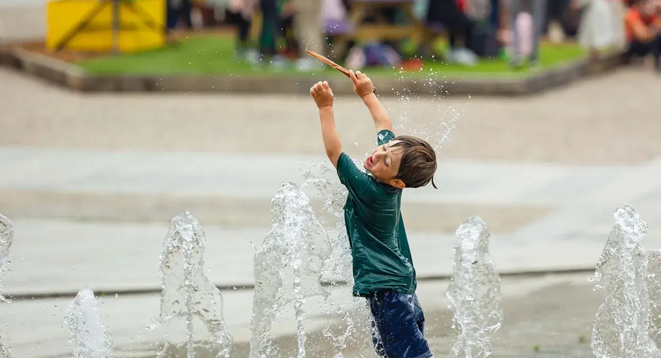 un enfant jouant dans les jets d'eau