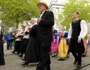 Des personnes défilent en costume traditionnel breton. 