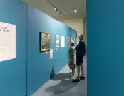 Deux personnes regardent des tableaux. 