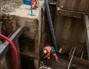 Deux ouvriers en train de travailler dans un trou.