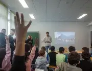 Des enfants lèvent la main dans une salle de classe.