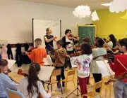 Des enfants jouant différents instruments de musique dans une classe 