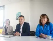 Trois personnes assises à une table.