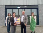 Quatre personnes posent devant un bâtiment.