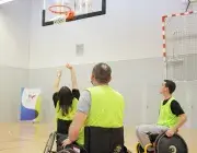 Des personnes en fauteuil roulant jouent au basket.
