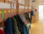 couloir d'une école avec des manteaux d'enfants accrochés au mur