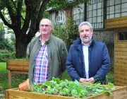 Deux hommes posent devant un bac à fleurs d'un jardin partagé à Brest. 