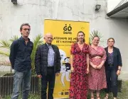 Des hommes et des femmes posent devant l'affiche du Go sens tour. 