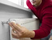 une personne en train de couper le chauffage