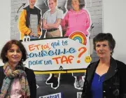 Deux femmes posent autour d'une affiche de la Mission locale du Pays de Brest. 