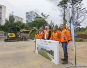 Plusieurs personnes posent devant un mur. 