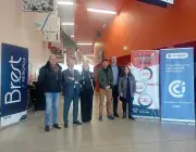 Plusieurs personnes posent devant des affiches.