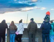 Des gens regardent un bateau partir. 