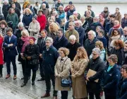 Des hommes et des femmes recueillis sur la place de la Liberté