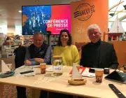 Une femme et deux hommes devant un écran présentant le visuel des Fêtes maritimes de Brest 2024