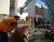 Un travailleur du bâtiment enlevant un sangle autour d'une pierre