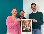 Une femme et deux hommes présentent une affiche