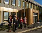 Plusieurs personnes devant un bâtiment.