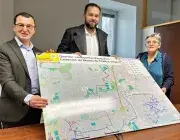 Deux hommes et une femme présentent le plan des travaux à Lambézellec. 