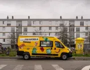 Un camion de tri garé devant des immeubles.