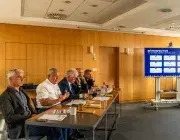 Plusieurs personnes assises à un bureau.