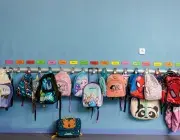 Des cartables d'écoliers accrochés au porte-manteaux. 