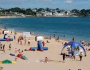 des personnes sur la plage du moulin blanc et dans l'eau