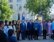 Plusieurs personnes devant une statue.
