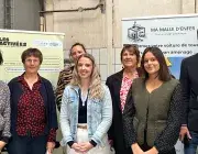Des homes et des femmes posent devant des panneaux