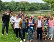 Un groupe d'hommes et de femmes posent sur les rives de Penfeld.  