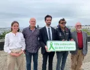 Des hommes et des femmes portant la plaque Ville ambassadrice du don d'organes 